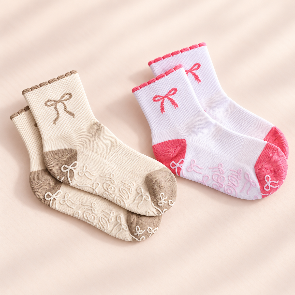 Pink and beige bow grip sock pairs on a neutral background