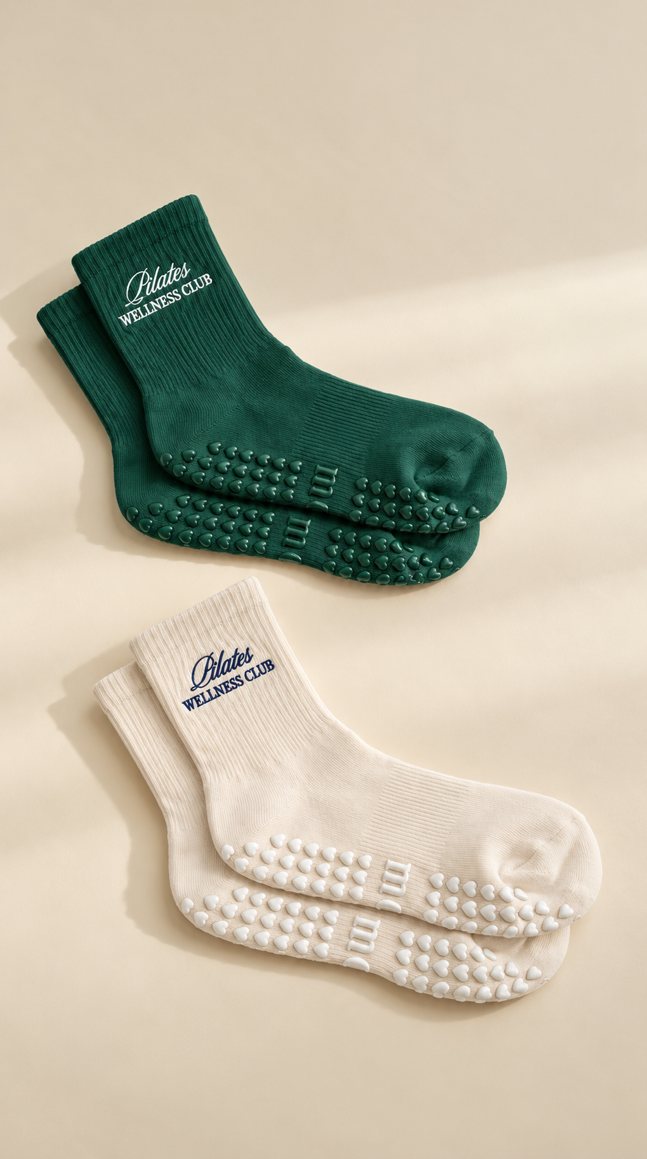 Pilates Wellness Club grip socks in forest green and almond beige on a neutral background
